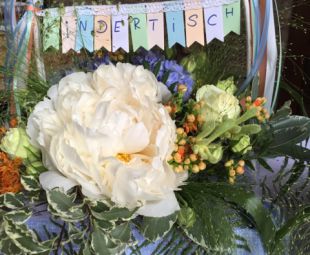 Hochzeits Kindertisch Dekoration: Vintagekorb mit floraler Blumendeko, Wimpelkette und Pastellbaendern