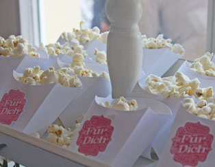 Event Begrüßungssnack: kleine Schachteln mit Textbutton "Für Dich" mit Popcorn gefüllt