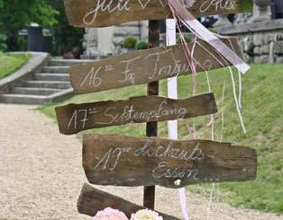 Hochzeits-Zeitablaufplan: Wo ist wann was, dekoriert mit Bändern in Pastell und großer Weidenkorb mit Hortensien in rosé