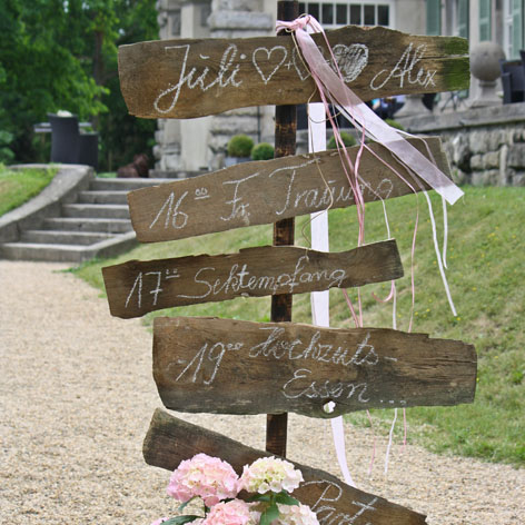 Hochzeits Ablaufplan: auf Holztafeln geschrieben, was ist wann und wo mit passenden Bändern